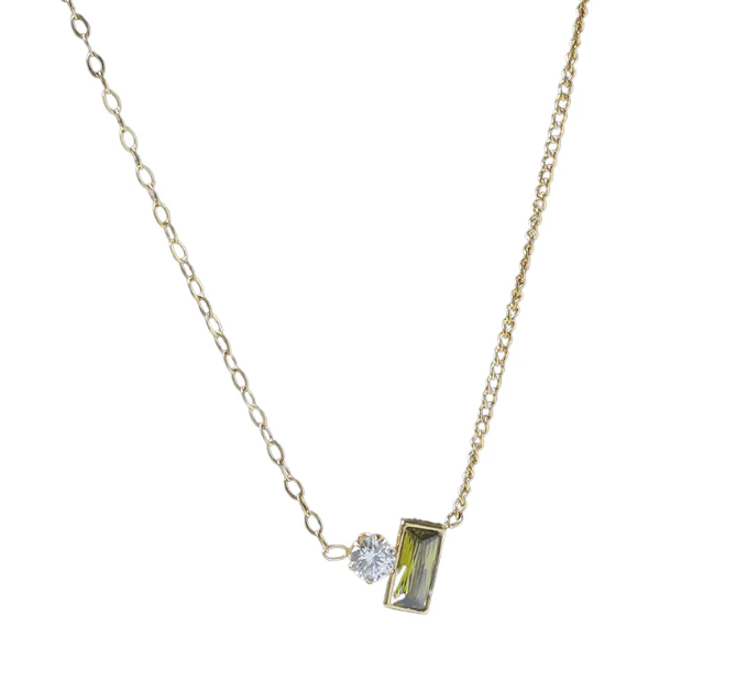 Gold necklace with a pendant featuring a green gemstone and a diamond