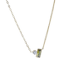 Gold necklace with a pendant featuring a green gemstone and a diamond