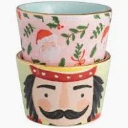 Two stacked ceramic pots with festive designs featuring Santa Claus and a nutcracker.