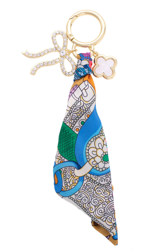 Colorful patterned keychain with a gold ring and clover and bow charm.