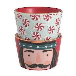 Set of two ceramic pots with decorative designs, one featuring a nutcracker face and the other with peppermint pattern.