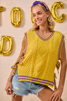 A yellow knitted vest with purple trim